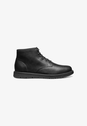 Zwarte leren enkelboots met een ronde neus, zes veters ogen en een gemarmerde rubberen zool voor grip en duurzaamheid.