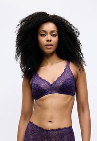 Bralette in pizzo viola con bordi scallopati e motivi floreali, abbinato a una mutandina in pizzo con cintura elastica.