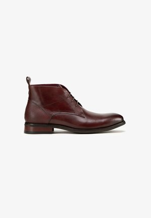 Burgundské kožené kotníkové boty s texturovaným panelem, hladkou špičkou, pěti dírkami na šněrování a dekorativním poutkem vzadu.