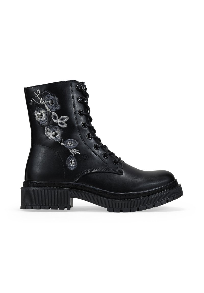 Botín negro de cuero con cordones, suela gruesa y bordado floral gris en el lado.