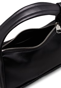 Černá kožená kabelka se zipovým uzávěrem, zakřiveným uchopem a jemně embosovaným logem. Hladký povrch s elegantním designem a stříbrnými detaily.