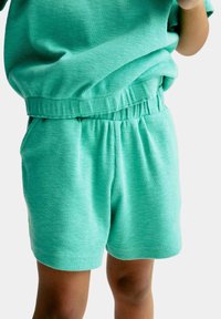 Myntegrønne shorts med elastisk talje og ribbet tekstur, udstyret med sidelommer og en afslappet pasform.