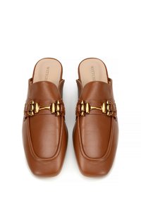 Scarpe slip-on in pelle marrone con punta arrotondata, dotate di un dettaglio a fibbia color oro sul davanti e una texture liscia e lucida.