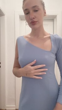 Svetlomodré priliehavé šaty s asymetrickým dizajnom a dlhým rukávom, vyrobené z hladkej látky. Minimalistický štýl s jemným leskom.