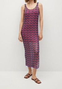 Robe maxi colorée en tissage avec un motif en zigzag de nuances rose, violet et vert. Présente des bretelles larges et une coupe décontractée.