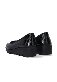 Schwarze Schuhe mit einem strukturierten, glanzvollen reptilartigen Muster, runder Aussparung an der Vorderseite und einer dicken, robusten Plateausohle.