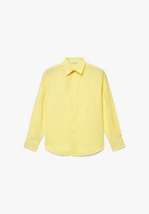 Chemise jaune à manches longues avec col pointu et poignets, design uni, présentée à plat sur fond blanc.