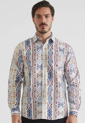 Chemise à manches longues pour homme en tissu blanc, ornée de motifs géométriques en bleu, rouge et or. Fini avec un col classique et une fermeture par boutons.