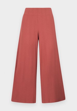 Wijde broekspijpen in een roestkleur, gemaakt van gestructureerde stof met verticale ribbels. Voorzien van een hoge, elastische tailleband.