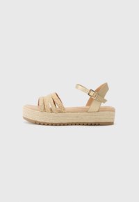 Strappy wedge sandals with a gold metallic back strap and woven beige front straps. Features a thick espadrille-style sole with texture.