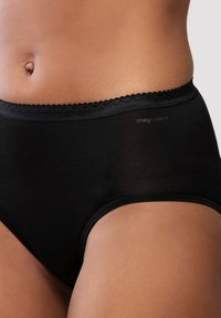 Der Oberkörper einer Frau trägt hochgeschnittene schwarze Unterwäsche mit Spitze und dem "mey LIGHTS"-Logo auf der linken Seite.