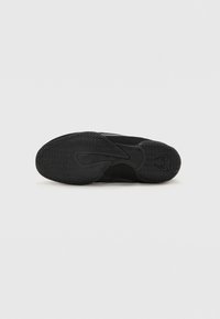 Suola di scarpa sportiva nera con gomma testurizzata, caratterizzata da un motivo a zigzag e dettagli con logo. Bordo liscio e forma arrotondata.