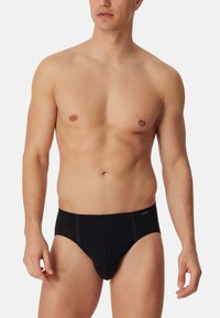 Zwarte boxershorts met contrasterende stiksels, met een low-rise tailleband en een zachte, rekbare stof. Eenvoudig ontwerp zonder patronen.