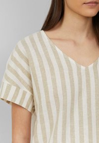 Linnenmix top met een V-hals, voorzien van afwisselend beige en witte strepen, korte mouwen en een relaxed fit. Subtiele textuur.