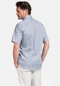 Chemise à manches courtes à boutons de couleur bleu clair avec un petit motif floral, dotée d'un col standard et d'un empiècement au dos.