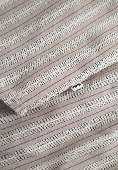Randig linneväv i taupe med vita och grå linjer. Har en liten vävd etikett med "W.W." i ett hörn. Slät textur.