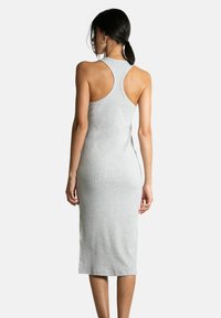 Robe midi grise à côtes avec un dos nageur et une silhouette ajustée, présentant une texture lisse et une longueur au genou. Vue arrière affichée.