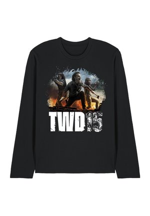 Drei entschlossene Personen mit Waffen stehen vor einem feurigen Hintergrund über dem Text "TWD 15" auf einem schwarzen Langarmshirt.