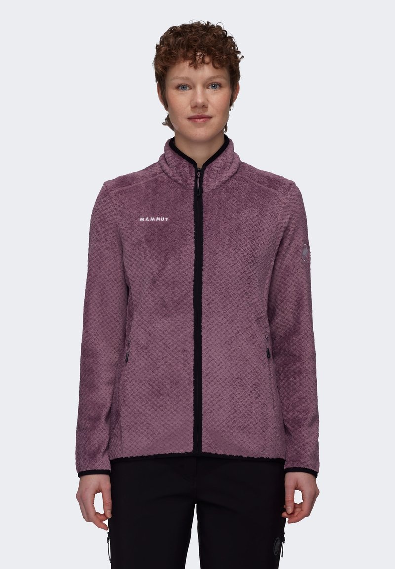 Chaqueta de forro polar morado con un acabado texturizado, collar alto y cremallera negra. Presenta el logo de Mammut en el pecho y bolsillos laterales.