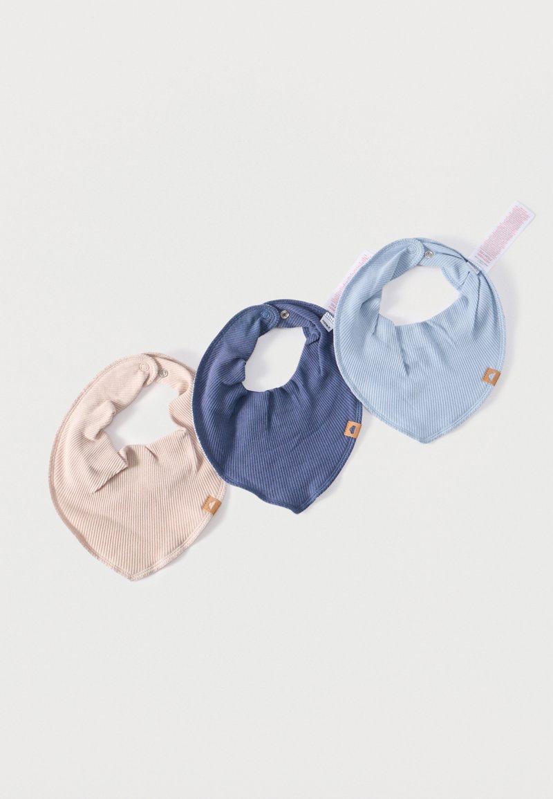 Trois bavoirs pour bébé en tissu côtelé, en beige, bleu marine et bleu clair, chacun équipé de fermetures à pression et de petites étiquettes marron, disposés sur un fond blanc.