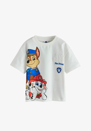 Fehér gyerek póló, melyen a Mancs őrjárat figurái: Chase kék rendőri egyenruhában és Marshall piros tűzoltó sapkában.