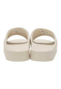 Béžové platformové sandály s hladkou texturou, otevřenou špičkou a širokými zaoblenými pásky. Plochá podrážka s nenápadnou značkovou etiketu.