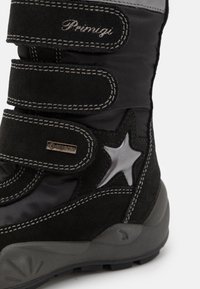 Zwarte winterlaars met een leren buitenkant, grijze accenten, verstelbare klittenbandsluitsingen en een zilveren sterontwerp. Gore-Tex-logo aanwezig.