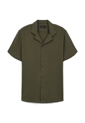 Chemise à manches courtes avec boutons de couleur vert olive, fabriquée dans un tissu texturé avec un col cranté et cinq boutons noirs sur le devant.