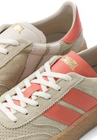 Baskets en daim beige avec bandes en cuir corail et détails talon, lacets blancs et logo doré "CAVAL" sur la languette.