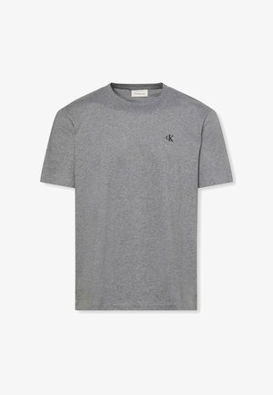 Camiseta de algodón gris con manga corta, cuello redondo y un pequeño logo negro en el pecho. Textura suave con un ajuste casual.
