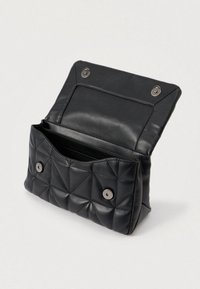 Crna kvadratna kožna torbica otvorena, prikazuje glatki unutrašnjost i magnetske kopče na poklopcu i prednjem dijelu.