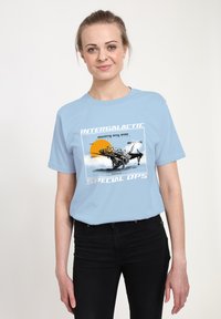 Světle modré bavlněné tričko s grafickým potiskem vesmírné lodi a oranžovým sluncem, s nápisem "INTERGALACTIC SPECIAL OPS" v bílé barvě.