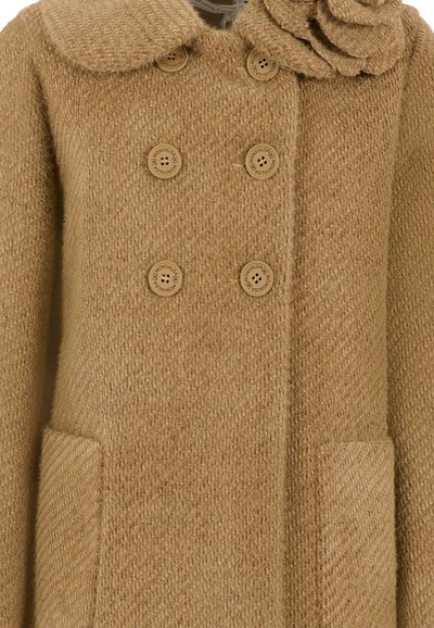 Cappotto cammello doppiopetto in tessuto texturizzato, colletto rotondo, sei bottoni griffati e tasche frontali a toppa.