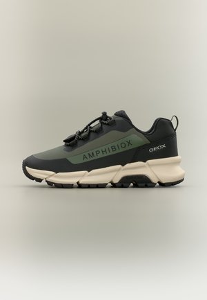 Baskets Amphibiox noires et vert foncé avec semelle blanche épaisse, fermeture à lacet avec bloqueur et marquage Geox au talon et sur le panneau latéral.