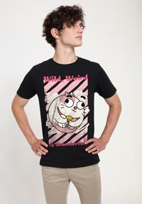 Sort T-shirt med en tegneseriekat, der spiser småkager, med pink tekst der siger "Vild, Underlig & Vidunderlig" og en stribet lyserød baggrund.