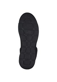 Suela de zapato hecha de goma negra, con una textura, un patrón de agarre y secciones elevadas para una mejor tracción. Bordes suaves sin hardware visible.