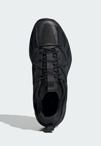 Scarpa da ginnastica nera con tomaia in rete testurizzata, colletto imbottito e punta rinforzata. Presenta lacci piatti e un design della suola intermedia che offre supporto.