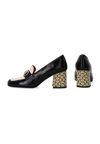 Zwarte lakleren loafers met een crème accent, gouden hardware en geperforeerde gele en zwarte blokhakken. Een gladde textuur en een slank ontwerp.