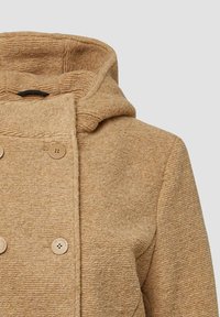 Beige Kapuzenmantel aus strukturiertem Rippstoff, mit doppelter Knopfverschluss und einem weichen, gemütlichen Aussehen.