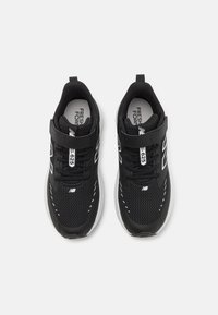 Chaussures de sport noires avec une tige en mesh, un col rembourré et des accents blancs. Elles disposent d'une sangle sécurisée et d'une semelle extérieure texturée pour une bonne adhérence.