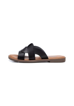 Sandale plate avec semelle beige et trois brides en cuir noir croisées sur le dessus, bout ouvert et style slip-on.