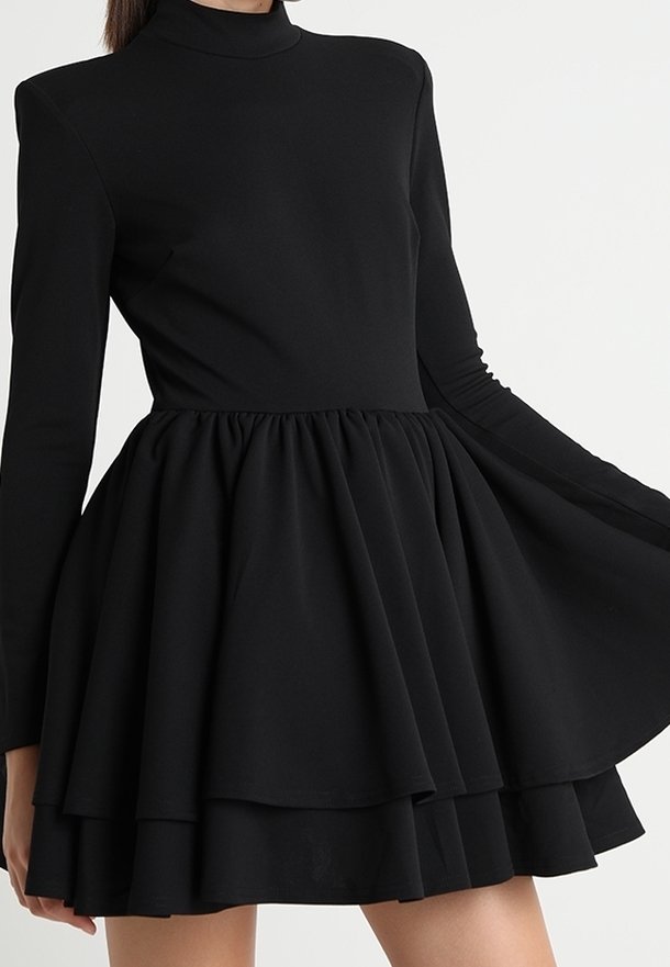 Mustat mekko korkealla kauluksella, pitkähihaisilla anteilla ja liehuvalla, kerroksittain leikatulla hameella. Valmistettu sileästä kankaasta, jossa on rypistetty vyötärö.