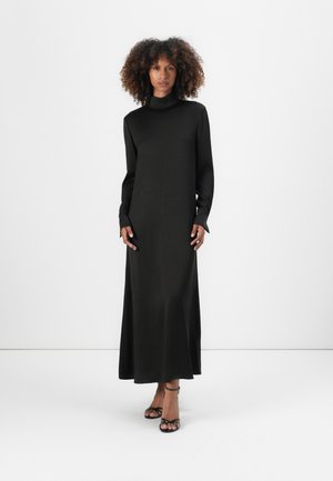 Long black dress with a high neck, long sleeves, and a flowing silhouette. Smooth texture and minimalist design with no visible patterns.