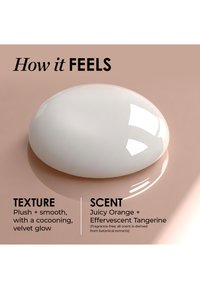 Objet ovale blanc brillant sur une surface beige avec un texte décrivant sa texture douce et lisse ainsi que son parfum juteux d'orange et de mandarine issu d'extraits botaniques.