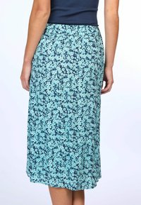 Flowy midi skirt in navy with a turquoise floral pattern. Elastic waistband and a smooth fabric texture, without visible hardware or accents.