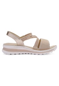Beige sandal with smooth leather and soft fabric, multiple strappy designs, a wide front band, and a cushioned sole with a wave pattern.