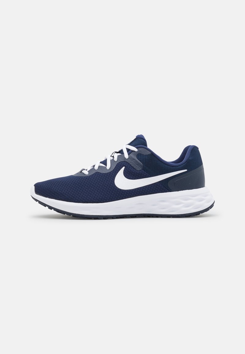 Chaussure de course Nike bleu marine avec logo Swoosh blanc, lacets blancs et semelle épaisse blanche amortie sur un fond clair uni.