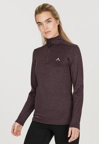 Langærmet zip-up skjorte i mørk maroon, fremstillet af struktureret stof. Har et tætsiddende design og et lille logo på brystet.