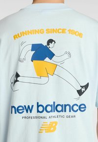 Gráfico de una persona corriendo con pantalones cortos amarillos, camiseta azul y zapatos negros sobre una camiseta de color azul claro; texto "CORRIENDO DESDE 1906" y logo de "new balance" abajo.