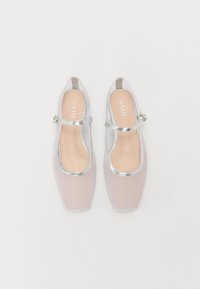 Pantofi slingback din plasă transparentă, cu vârful pătrat, accente argintii și o singură curea ajustabilă. Talpă de culoare roz deschis.